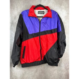 May include: A vintage Members Only jacket in a color block design. The jacket features a red collar and lower section, a blue upper section, and black sleeves and side panels. The jacket has a full zipper and the brand name is visible on the inside.