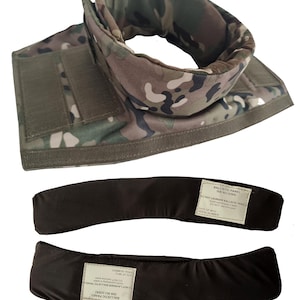 Peut inclure: Un col balistique à motif camouflage avec des attaches auto-agrippantes. En dessous, deux panneaux balistiques noirs, chacun avec une étiquette contenant du texte sur le lavage et les numéros de série. Le col est conçu pour la protection.