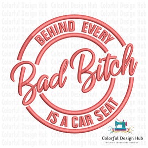 May include: A coral-colored design with the text "BEHIND EVERY Bad Bitch IS A CAR SEAT" in a circular layout. The design is likely for machine embroidery, as indicated by the sewing machine icon.