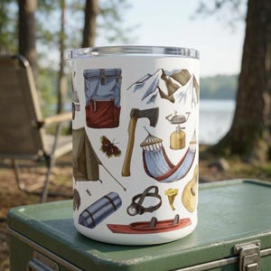 May include: White travel mug featuring camping-themed illustrations, including a backpack, axe, tent, hammock, and mountains. The design incorporates a color palette of red, blue, brown, and green, evoking an outdoor adventure theme.