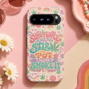 May include: A rectangular phone case featuring a cream background with a colorful pattern of rainbows, flowers, and cannabis leaves. The text reads: Some people like to stir the pot I prefer to smoke it. The case has a black camera cutout at the top.