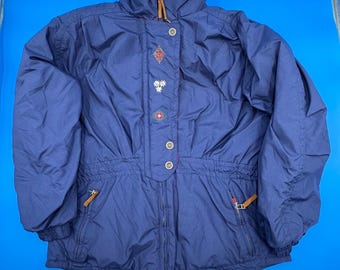 May include: A navy blue winter jacket with a red collar and decorative buttons. The jacket has a high collar, a zip closure, and two front pockets with brown leather zip pulls. The jacket features embroidered details and a cinched waist.