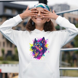 May include: White hoodie featuring a vibrant, colorful graphic of a snarling dog's head. The artwork uses a splash paint effect with shades of blue, purple, yellow, and pink. The hoodie has a front pocket and a drawstring hood.