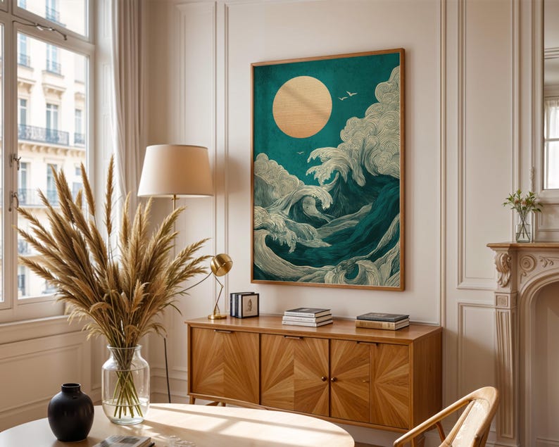 K&ouml;nnte beinhalten: Ein gerahmter Kunstdruck, der eine stilisierte Ozeanszene mit einer gro&szlig;en goldenen Sonne und brechenden Wellen in T&uuml;rkis- und Wei&szlig;t&ouml;nen zeigt. Das Kunstwerk wird &uuml;ber einem Holzschrank in einem hellen Raum ausgestellt.