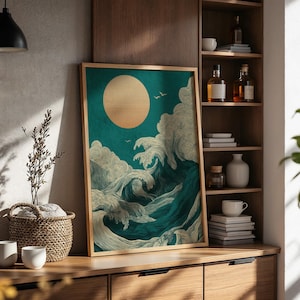 K&ouml;nnte beinhalten: Ein gerahmter Kunstdruck mit stilisierten Meereswellen und einer gro&szlig;en Sonne. Das Kunstwerk verwendet T&uuml;rkis-, Wei&szlig;- und Goldt&ouml;ne. Der Druck wird auf einem Holzschrank mit dekorativen Gegenst&auml;nden ausgestellt.