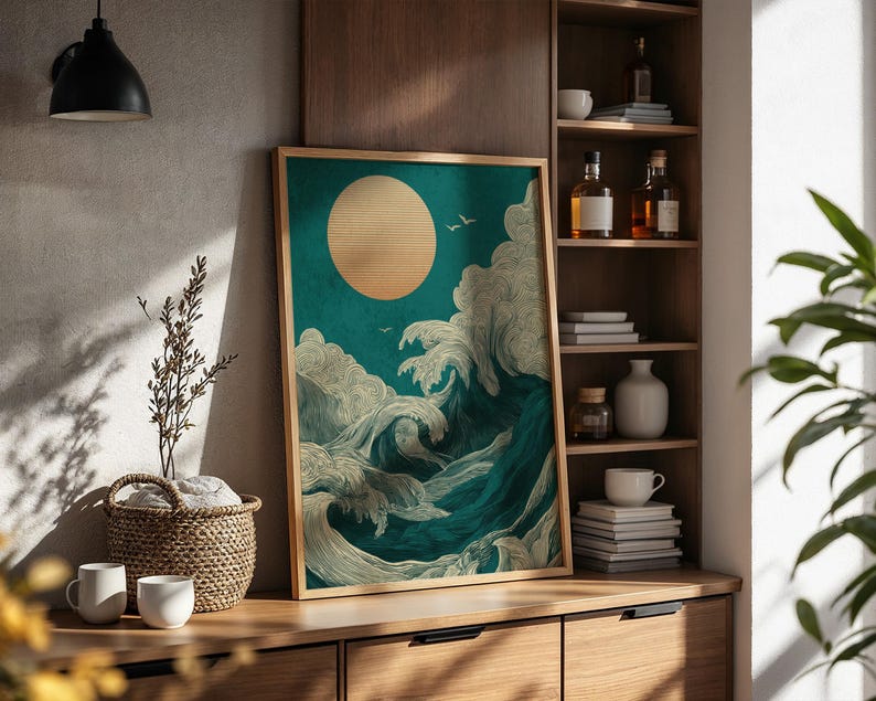 K&ouml;nnte beinhalten: Ein gerahmter Kunstdruck mit stilisierten Meereswellen und einer gro&szlig;en Sonne. Das Kunstwerk verwendet T&uuml;rkis-, Wei&szlig;- und Goldt&ouml;ne. Der Druck wird auf einem Holzschrank mit dekorativen Gegenst&auml;nden ausgestellt.