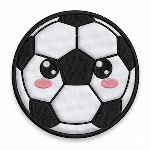 Könnte beinhalten: Ein runder Aufnäher mit einem Fußball-Design mit einem niedlichen Gesicht. Der Ball ist weiß mit schwarzen Fünfecken und Sechsecken, einem schwarzen Rand, großen Augen und rosa Wangen. Ideal für Sportfans.