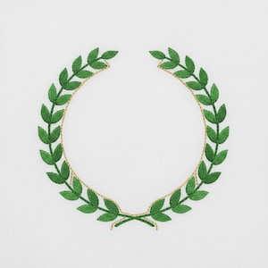Könnte beinhalten: Grüner, gestickter Lorbeerkranz auf weißem Hintergrund. Der Kranz besteht aus grünen Blättern und einer goldfarbenen Umrandung, die ein kreisförmiges Design bilden. Die Blätter sind mit sichtbaren Stichen detailliert, was ein strukturiertes Aussehen erzeugt. Geeignet für Stickprojekte.