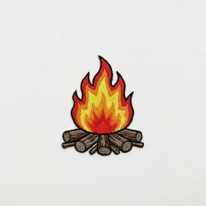 Può includere: Toppa ricamata con un disegno di falò. Le fiamme sono nei toni del rosso, arancione e giallo, sopra un mucchio di tronchi marroni. La toppa è progettata per essere cucita su indumenti o accessori.