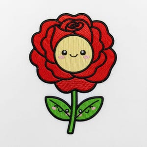 Op de afbeelding: Geborduurde patch met een lachende rode roos met een gele kern en groene bladeren. De roos heeft een zwarte omtrek en de bladeren hebben lachende gezichten. De patch is ontworpen in een schattige, cartoonachtige stijl.