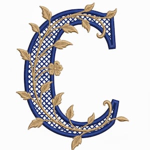 Op de afbeelding: Een marineblauwe geborduurde letter "C" met een gouden bloemenrankenontwerp. De binnenkant van de letter heeft een roosterpatroon, met gouden bladeren en een kleine bloem. Het ontwerp staat tegen een witte achtergrond.