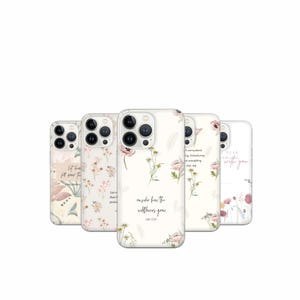 May include: A collection of floral phone cases with various designs. The cases feature delicate watercolor flowers in pink, white, and green, with inspirational quotes. The cases are arranged in a row, showcasing the different designs.