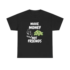 Puede incluir: Camiseta negra con el texto blanco "MAKE MONEY NOT FRIENDS". El diseño incluye un signo de dólar y una pila de dinero en verde y blanco. La camiseta está hecha de un material suave.