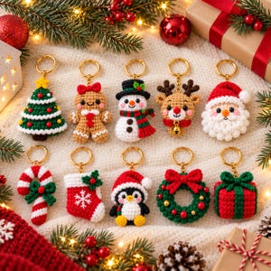 May include: A collection of ten crocheted Christmas-themed keychains featuring a tree, gingerbread person, snowman, reindeer, Santa Claus, candy cane, stocking, penguin, wreath, and gift box, all attached to gold-toned metal rings.