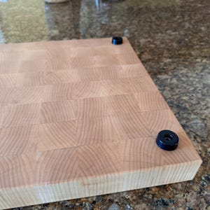 Underside view showing non-slip rubber feet on an end grain hard maple cutting board; stabilizes the board and protects countertops.