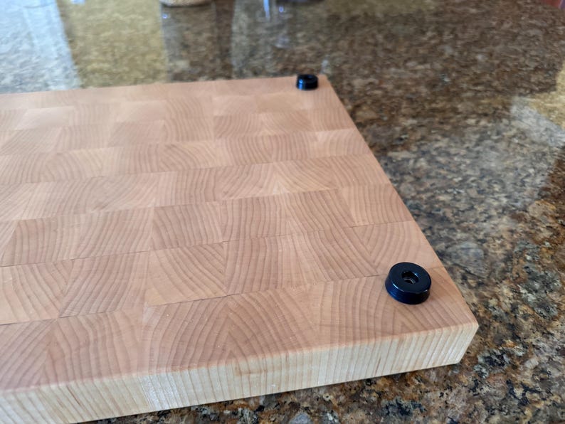 Underside view showing non-slip rubber feet on an end grain hard maple cutting board; stabilizes the board and protects countertops.
