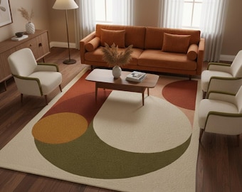 May include: A living room scene featuring a rust-colored sofa with matching throw pillows, two cream-colored armchairs, and a wooden coffee table. A patterned rug with geometric shapes in cream, brown, and green tones sits on a hardwood floor. A floor lamp and a wooden cabinet complete the decor.