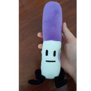 May include: A plush toy in the shape of a purple and white marker, featuring black facial details and feet. The toy has a purple top, a white body with a face, and black feet. It is designed to resemble a cartoon character.
