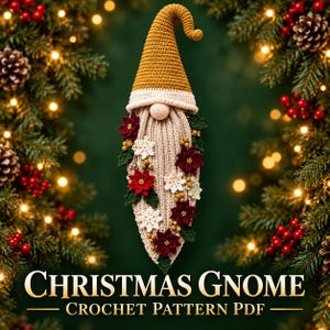 May include: A crochet gnome ornament featuring a tall mustard yellow hat with a curled tip, a cream-colored brim, and a long, textured beige beard. The beard is decorated with small crocheted red poinsettia flowers, white snowflakes, green leaves, and tiny yellow berries.