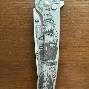 Unique etched folding knife with a pirate ship design