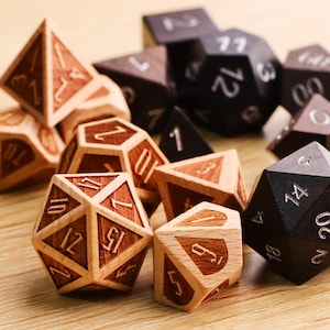 May include: A collection of wooden polyhedral dice in various shapes and sizes. The dice are made of light and dark wood, with engraved numbers. Some dice are light brown with dark brown numbers, while others are dark brown with silver numbers.