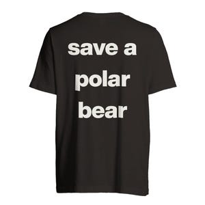 Peut inclure: T-shirt noir avec l'inscription blanche "save a polar bear" en caractères gras sans empattement. Le texte est disposé sur trois lignes, chaque mot étant centré. Le t-shirt est en matière souple.