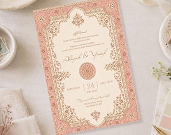 May include: A rectangular wedding invitation card featuring a cream-coloured centre with elegant dark text and a dusty pink border decorated with intricate gold floral patterns. The text includes names Aliyah and Yusuf, date, and location details.