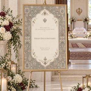 May include: A rectangular welcome sign in a gold frame featuring a beige center with a Khanda symbol and text reading Welcome to Sri Sukhmani Sahib Path of Kiran Kaur Matharu with love and blessings, surrounded by a grey floral border.