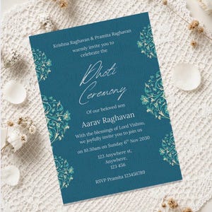 May include: Teal invitation card with floral corner designs. The card announces a 'Photi Ceremony' for Aarav Raghavan, with details including the date, time, and location. The card is decorated with floral accents.