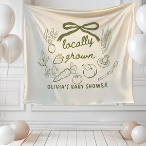 Może przedstawiać: Kremowy baner z napisem "locally grown" i ilustracjami warzyw i owoc&oacute;w. Baner zawiera r&oacute;wnież napis "Olivia's Baby Shower". Białe balony i beżowe kule zdobią scenę.