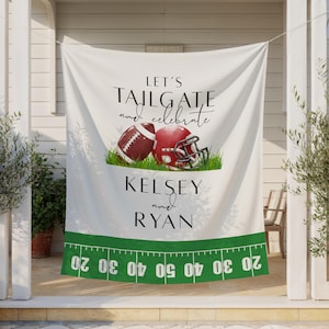 Op de afbeelding: Een wit stoffen spandoek met de tekst LET'S TAILGATE and celebrate, een football, een rode helm, de namen KELSEY en RYAN, en een groen footballveld-grafiek onderaan met de cijfers 20, 30, 40, 50, 40, 30, 20.