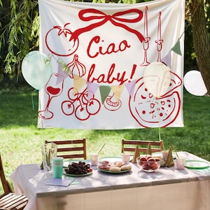 May include: A festive outdoor party scene with a white banner featuring red illustrations of Italian food and the phrase "Ciao baby!". A table is set with food, drinks, and plates. Balloons in various colors are scattered around the scene.