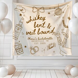 May include: A cream-colored banner with the text "whiskey bent & veil bound" and illustrations of a cowboy hat, whiskey bottle, boots, and rings. White balloons and other decorations are in the background. The banner is for Olivia's bachelorette party in Nashville, TN, in 2025.