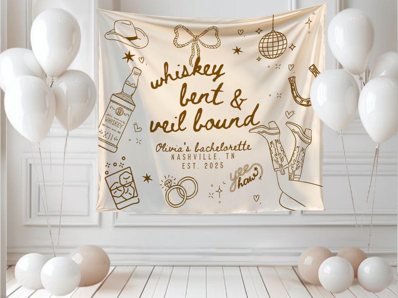 May include: A cream-colored banner with the text "whiskey bent & veil bound" and illustrations of a cowboy hat, whiskey bottle, boots, and rings. White balloons and other decorations are in the background. The banner is for Olivia's bachelorette party in Nashville, TN, in 2025.