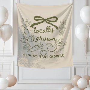 Może przedstawiać: Beżowy baner z zieloną kokardą i napisami "locally grown" i "Olivia's Baby Shower" w odręcznym kroju pisma. Baner zawiera ilustracje warzyw i owoc&oacute;w. Białe i beżowe balony na pierwszym planie.