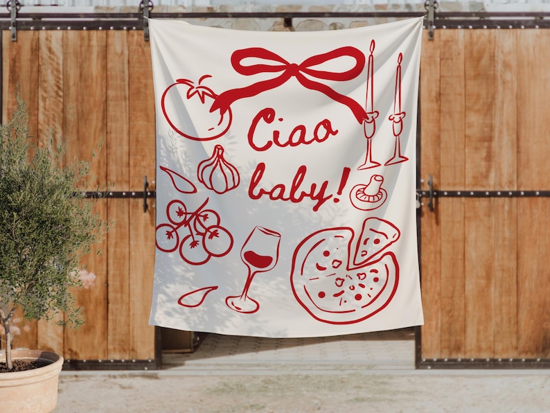 May include: A white fabric wall hanging with a red illustration of Italian food items, including a tomato, garlic, pizza, and wine glass. The phrase "Ciao baby!" is written in red script.