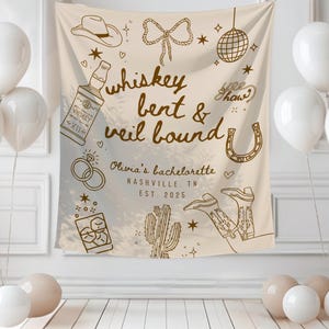 May include: A beige bachelorette party backdrop with the text "whiskey bent & veil bound" and illustrations of a cowboy hat, boots, and a horseshoe. White balloons and decorative elements complete the scene.