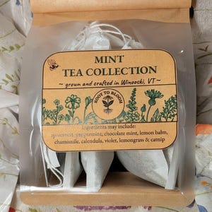 May include: A clear plastic bag with a brown paper top, containing tea bags. The label reads "MINT TEA COLLECTION" with a list of ingredients. The tea is grown and crafted in Winooski, VT.