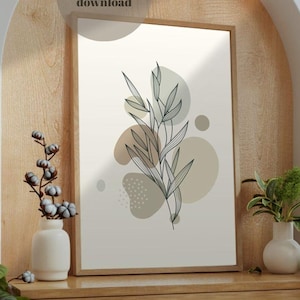 May include: A framed art print with a botanical illustration of leaves and abstract shapes in neutral tones. The artwork is displayed on a wooden cabinet with decorative vases and plants. The text "digital download" is visible.