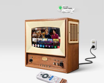 Könnte beinhalten: Ein hölzernes Fernsehgerät im Retro-Stil mit cremefarbenem Rahmen und einem digitalen Bildschirm, der ein Friends-Episodenmenü anzeigt. Das Gerät verfügt über vordere Drehregler, ein seitliches Lautsprechergitter, ein Stromkabel und eine Fernbedienung.