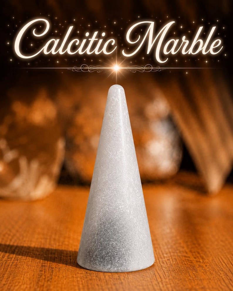 K&ouml;nnte beinhalten: Ein kegelf&ouml;rmiges Objekt aus hellgrauem calcitischem Marmor mit einer glatten, gesprenkelten Textur. Der Text 'Calcitic Marble' ist in wei&szlig;er Schreibschrift &uuml;ber dem Objekt zu sehen, begleitet von einem kleinen, hellen Sterneneffekt.
