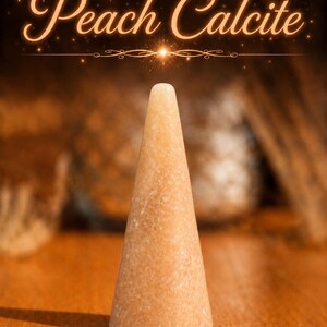 K&ouml;nnte beinhalten: Ein glattes, kegelf&ouml;rmiges Objekt aus Pfirsich-Calcit mit einer hellorangen, gesprenkelten Optik. Der Text Peach Calcite erscheint in einer leuchtenden Schreibschrift &uuml;ber dem Steinobjekt, das eine abgerundete Spitze und eine flache Basis hat.