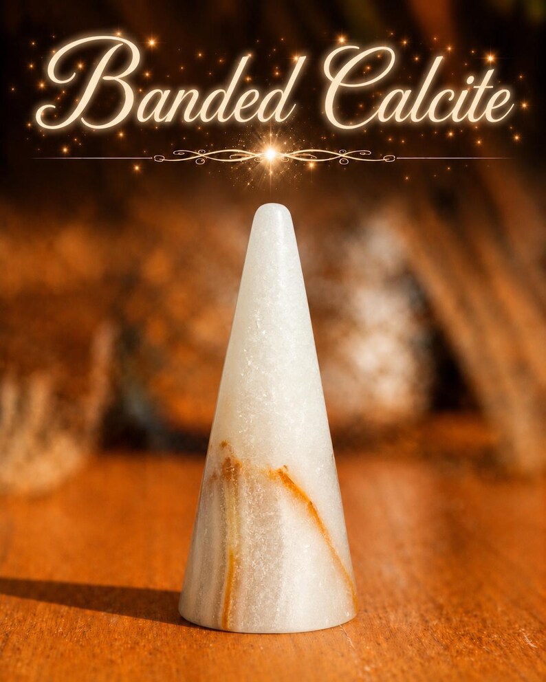 K&ouml;nnte beinhalten: Ein konischer Ringhalter aus wei&szlig;em geb&auml;ndertem Calcit mit sichtbaren orange-braunen Mineraladern. Der Text "Banded Calcite" erscheint in einer leuchtend wei&szlig;en Schreibschrift &uuml;ber dem Steinobjekt, das eine glatte, polierte Oberfl&auml;che hat.