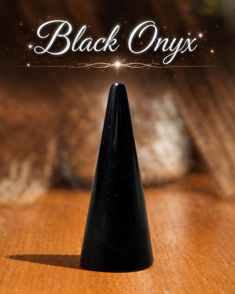 K&ouml;nnte beinhalten: Ein glatter, polierter schwarzer Onyxstein, der in eine hohe, schlanke Kegelform geschliffen ist. Die Oberfl&auml;che des Steins ist dunkel und reflektierend. &Uuml;ber dem Stein steht der Text Black Onyx in einer wei&szlig;en, eleganten Schreibschrift.