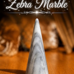 K&ouml;nnte beinhalten: Ein kegelf&ouml;rmiges Objekt aus Zebramarmor mit einer glatten, polierten Oberfl&auml;che, die wirbelnde graue und wei&szlig;e Muster aufweist. Der Text "Zebra Marble" ist in einer wei&szlig;en Schreibschrift &uuml;ber dem Objekt dargestellt, akzentuiert durch kleine sternartige Funken.
