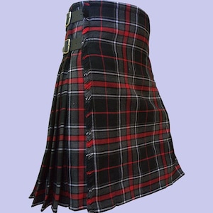 Pode incluir: Um kilt tradicional com um padrão xadrez preto, vermelho e cinza. O kilt apresenta um design plissado, tiras de couro com fivelas douradas e bordas com franjas. Esta peça de vestuário é uma peça clássica do vestuário escocês.