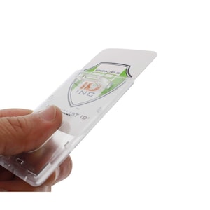May include: Clear plastic ID badge holder with a spring clip. The holder has a slot for a card and a clear window to display the card. The text "Specialist ID" is printed on the card.