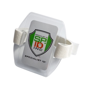 May include: White plastic ID badge holder with an adjustable strap. The holder has a clear window for displaying an ID card. The holder has the logo "Specialist ID Inc." printed on it.