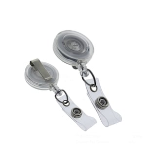 May include: Two clear retractable badge holders with a silver clip and a clear strap. The holders are made of plastic and have a spring-loaded mechanism that retracts the strap.