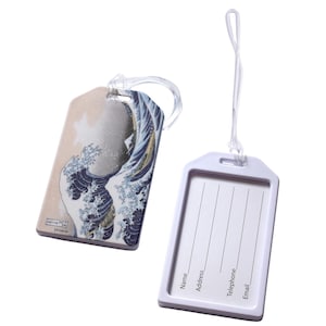 May include: Two luggage tags. One tag features a print of Hokusai's "The Great Wave off Kanagawa" in shades of blue, beige, and white. The other tag is white with space for name, address, phone, and email. Both tags have clear plastic loops.
